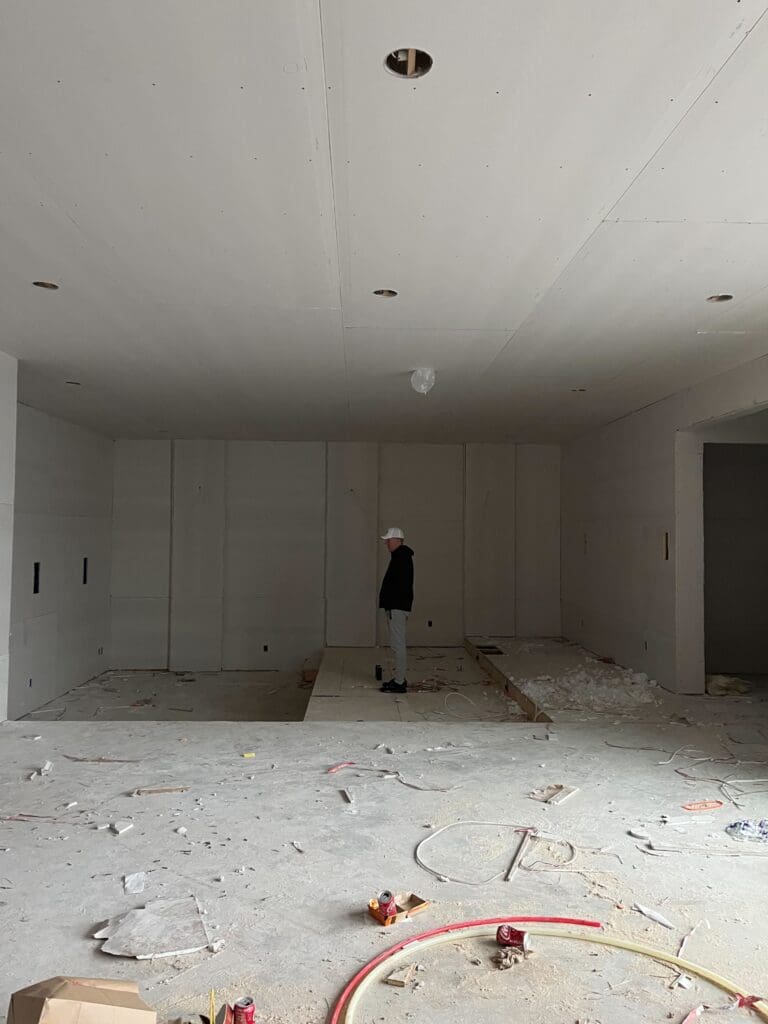 My home under construction with drywall installed and ceilings painted in matching color, highlighting the early stages of applying elevated paint techniques with wall and ceiling uniformity.