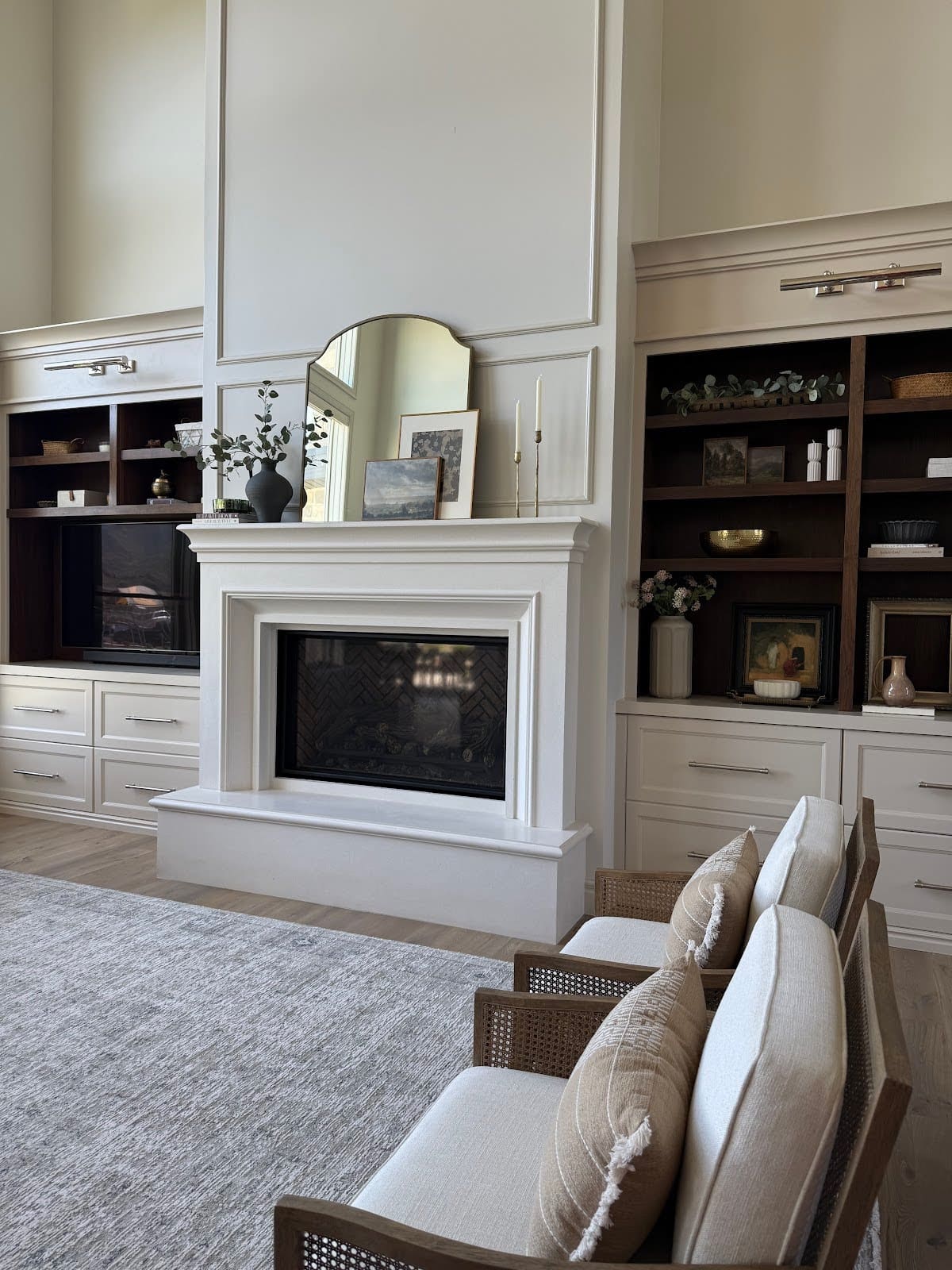 Full view of our living room fireplace flanked by built-in two-tone cabinetry.