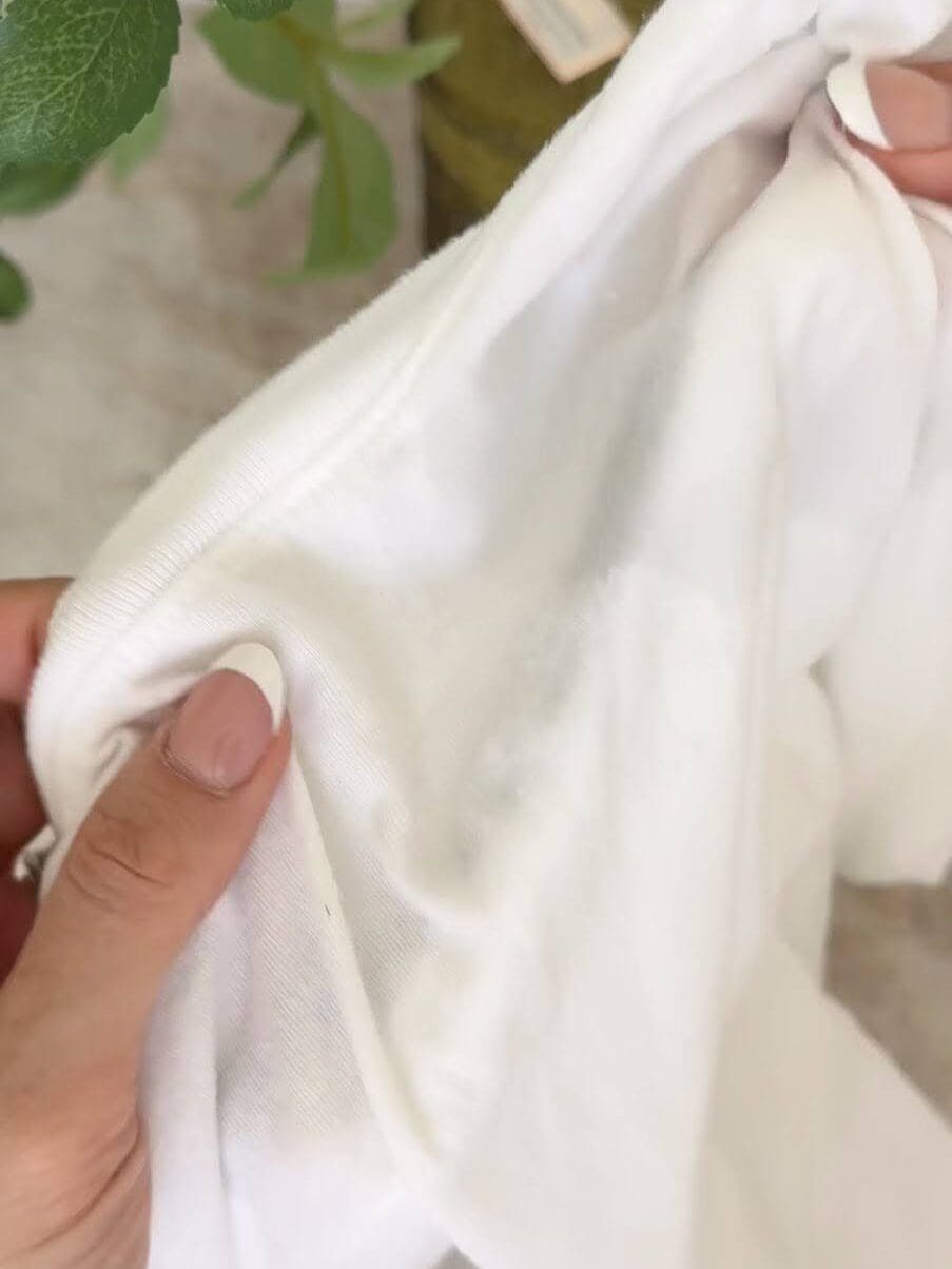Applying the Amazon laundry spray to the blackberry stain on the shirt