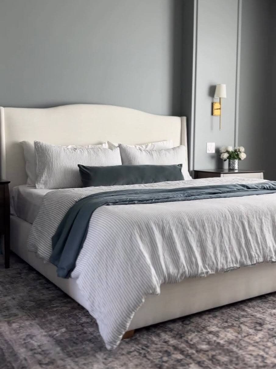 Neutral primary bedroom styled with upholstered bed, layered bedding, and Amazon duvet insert.