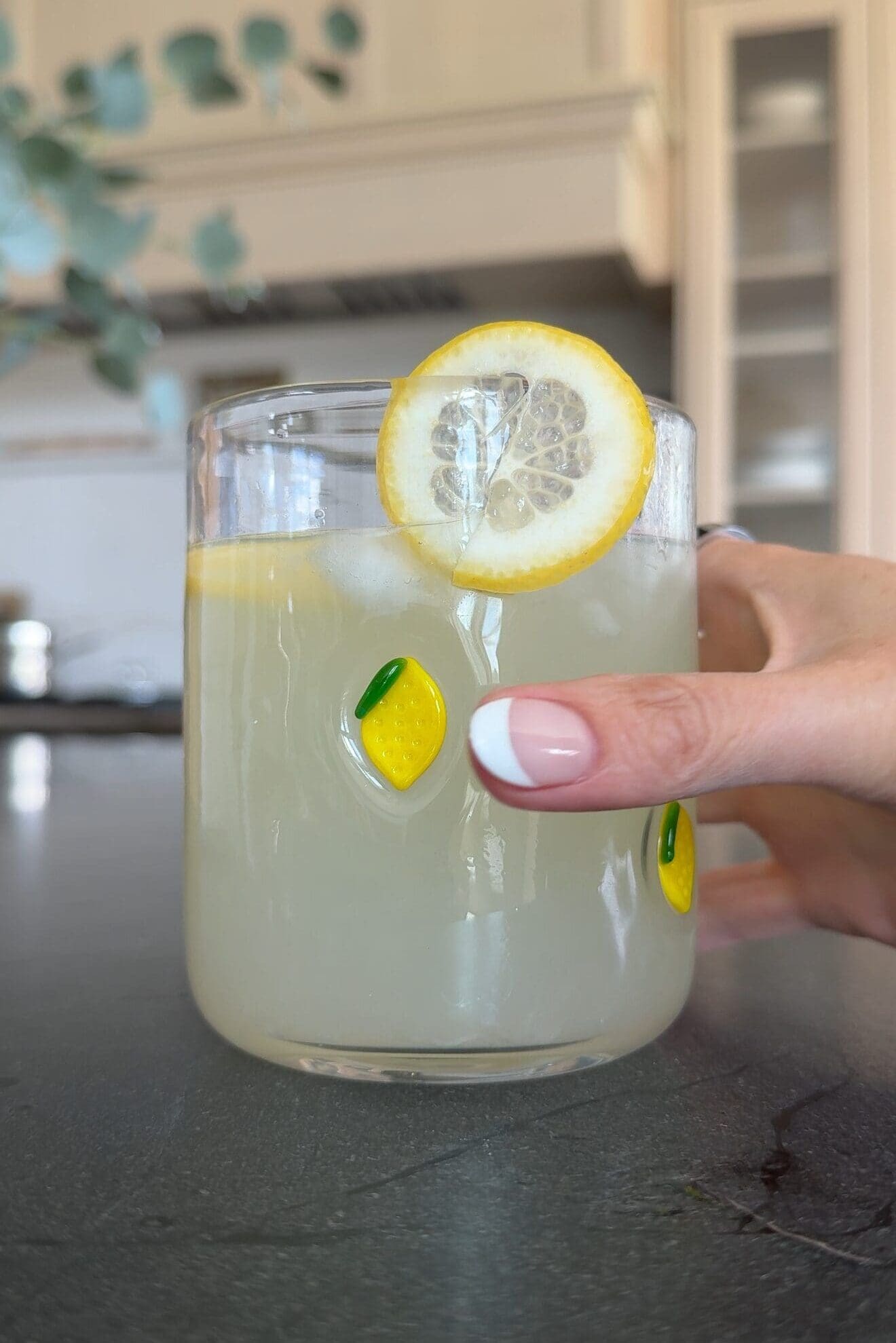 Lemon glass cup filled with lemonade and garnished with a fresh lemon slice