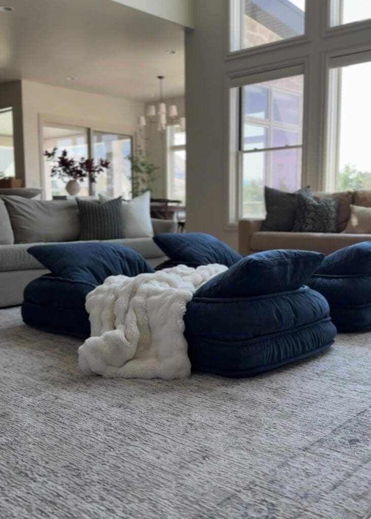 Cozy navy floor beds with a white faux fur blanket, styled in the living room