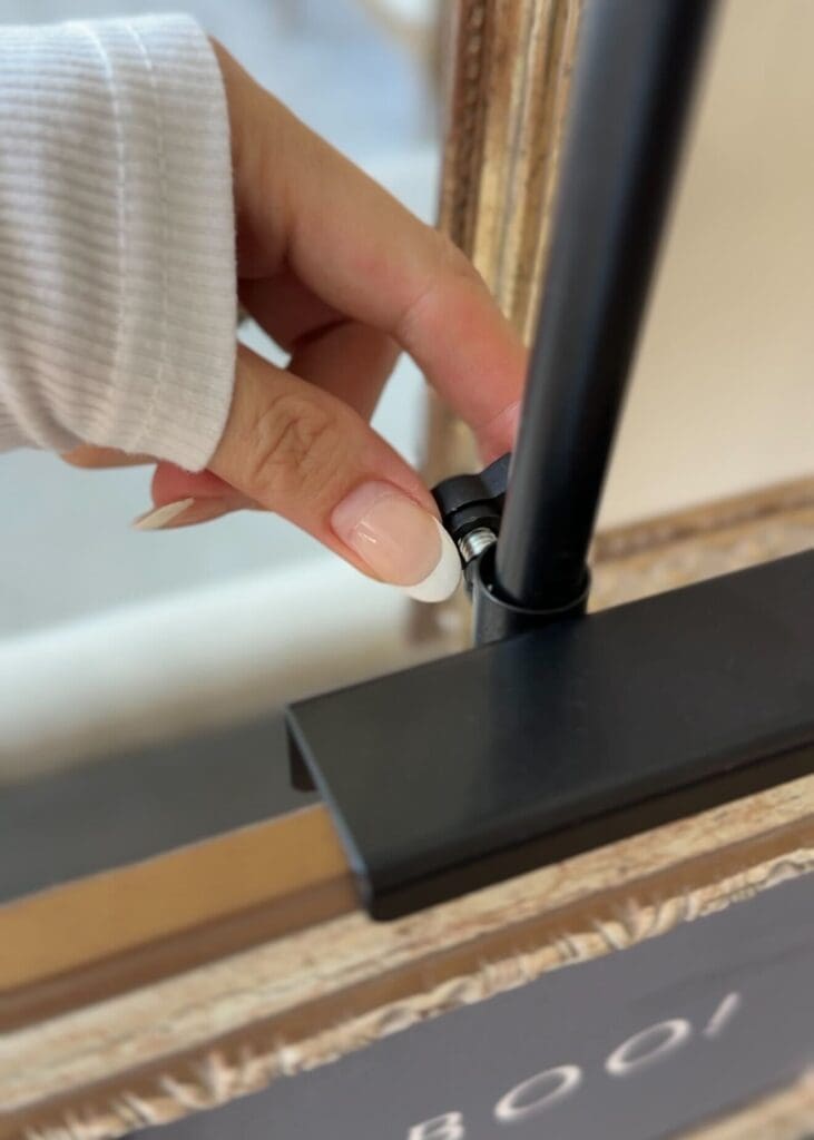 Close-up of hand adjusting the screw on an adjustable art easel