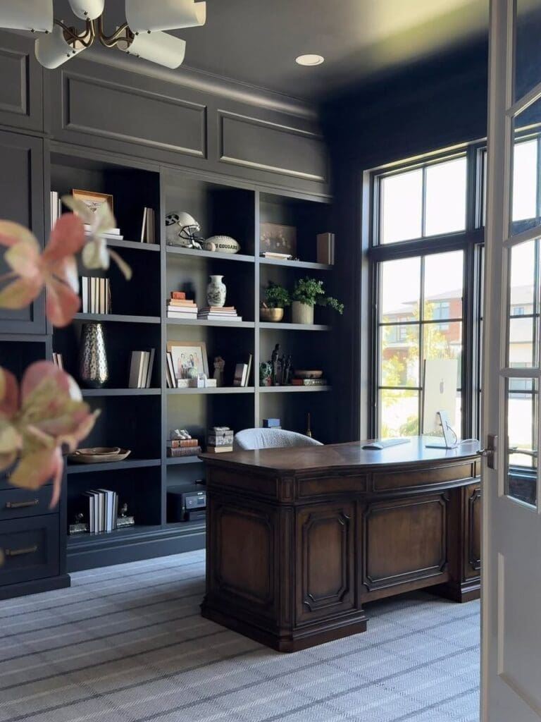 Real office: dark built-ins, wood desk, large windows.