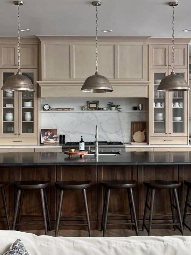 Real home kitchen: white oak cabinetry, marble backsplash, dark island.