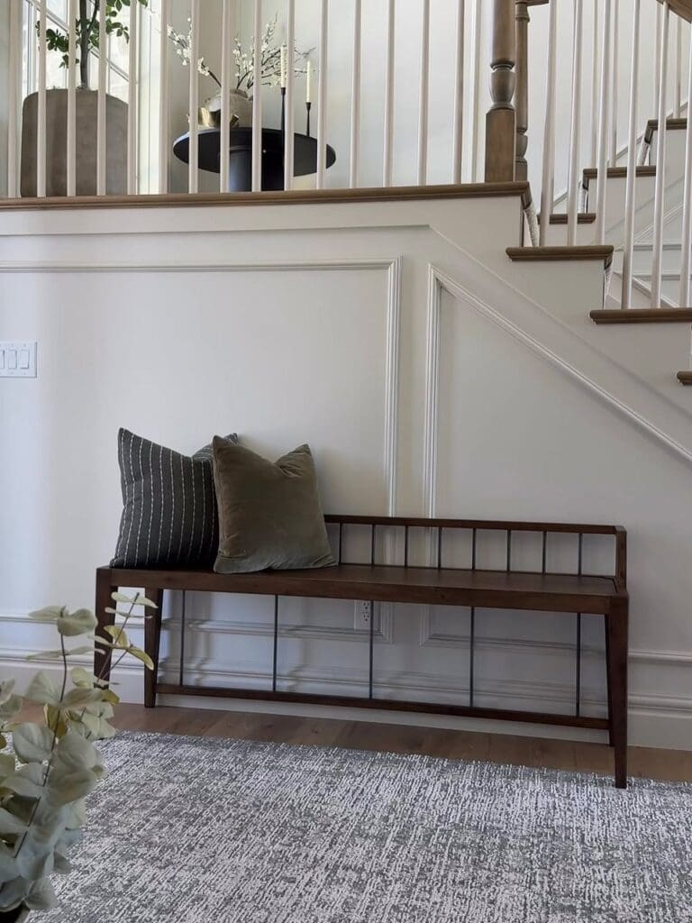 Real stair landing with wood bench and pillows.