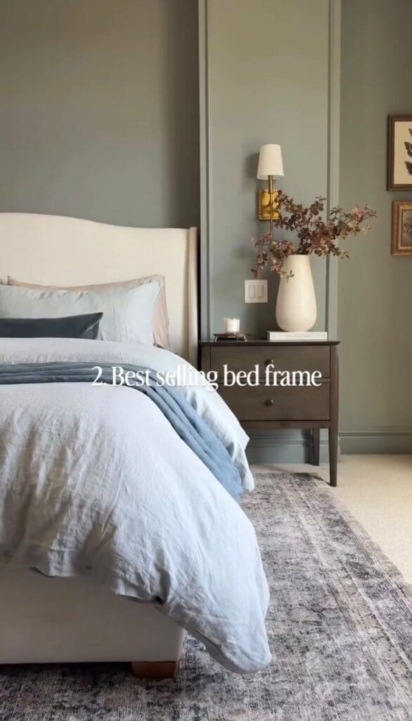Neutral upholstered bed frame styled with layered bedding in a serene bedroom.