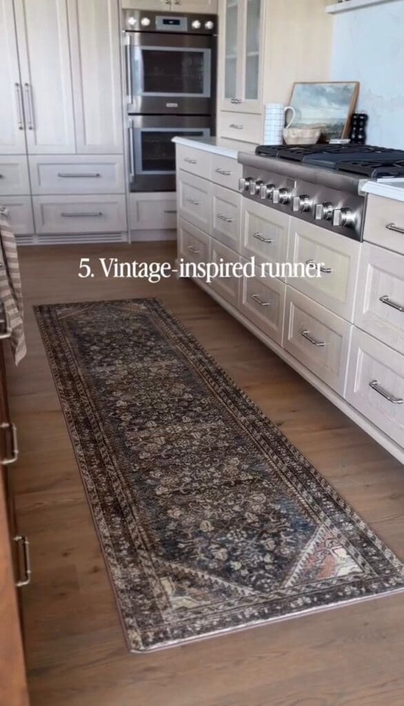 Vintage-style runner rug placed in a white kitchen with stainless steel appliances.